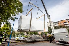 Den första av tre nya tvättstugor lyfts på plats vid Stavbygränd i Rinkeby.
