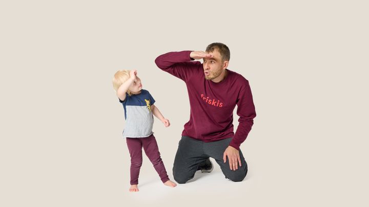 En vuxenoch ett barn håller handen vid pannan som om de spejar.