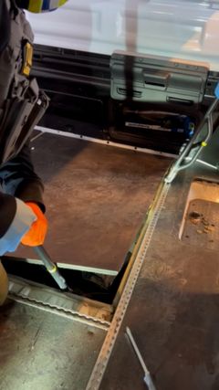 Tullen öppnar det dolda utrymmet i den vita skåpbilen. OBS! Videograb.