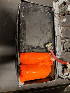 Batteriets lock är helt avplockat och ombyggnationen av batteriet syns tydligt. De två översta paketen av metamfetamin är istoppade i plasthandskar. Foto: Tullverket.