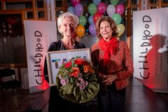 Vinnaren av Childhoodpriset, Bitte Johnsson, tillsammans med H.M. Drottningen.