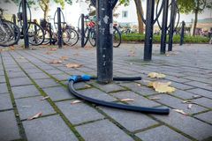 En cykelställning med en trasig cykellås på marken och cyklar i bakgrunden.