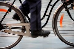 En person cyklar snabbt med en suddig bakgrund.