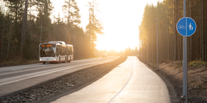 G%E5ng-%20och%20cykelv%E4g%20bredvid%20en%20bilv%E4g%20d%E4r%20en%20buss%20k%F6r%20i%20motljuset.