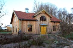 Trähus på två våningar med grön och lummig trädgård intill.