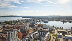 Vybild över centrala Jönköping med olika typer av byggnader, gator, en rondell och sjöar syns.