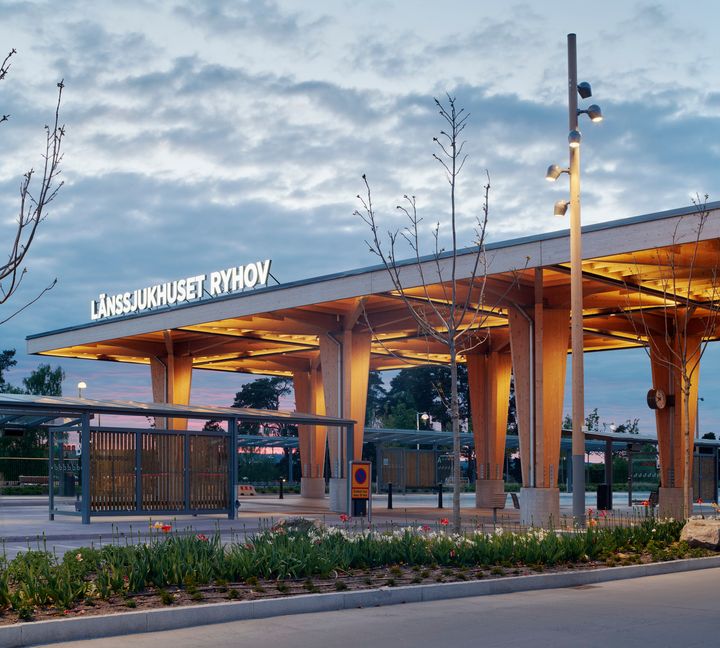 L%E4nssjukhusets%20nya%20entr%E9plats%20sett%20fr%E5n%20sidan.%20En%20tr%E4konstruktion%20i%20form%20av%20tak%20och%20pelare%20med%20belysning%2C%20med%20texten%20L%E4nssjukhuset%20Ryhov.%20Intill%20syns%20en%20bussh%E5llplats%20och%20en%20rad%20med%20gr%F6n%20plantering.