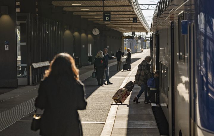 Resenärer som går på ett Mälartåg på Uppsala station.