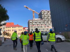 En grupp myndighetskontrollanter i gula västar på en byggarbetsplts