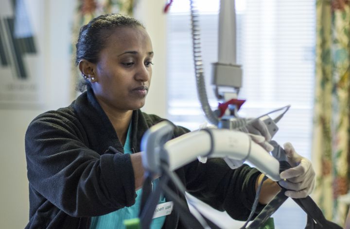 Person hanterar medicinsk utrustning i ett vårdrum.