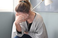 Trött kvinna skyler sitt ansikte med ena handen