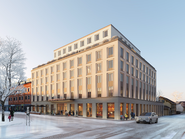 Modernt flerbostadshus i vintermiljö med snö på marken och träd i bakgrunden.