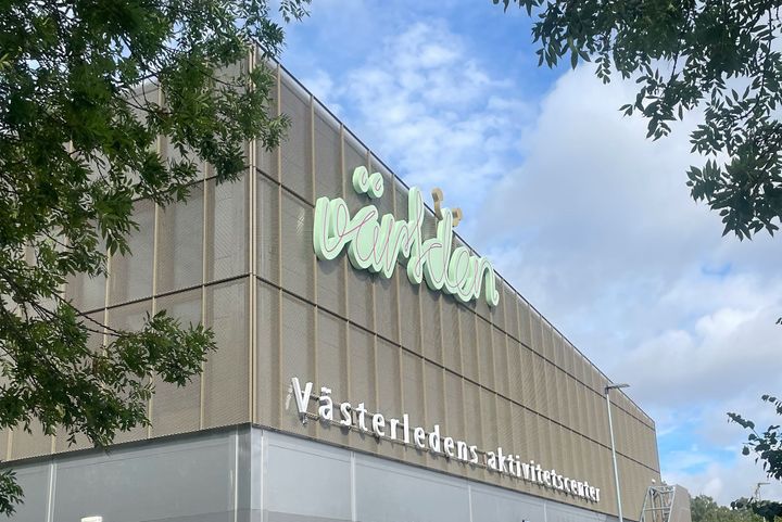 Byggnad med texten "Västerledens aktivitetscenter" och "världen" på fasaden.