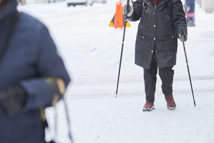 Person med gåstavar på vinterväglag