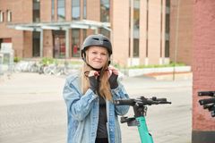 Bild som föreställer ung kvinna som knäpper en hjälm