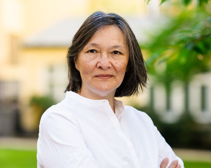 Porträtt av Sylvia Schwaag Serger, vd för IVA, i vit skjorta utomhus med grönska i bakgrunden.