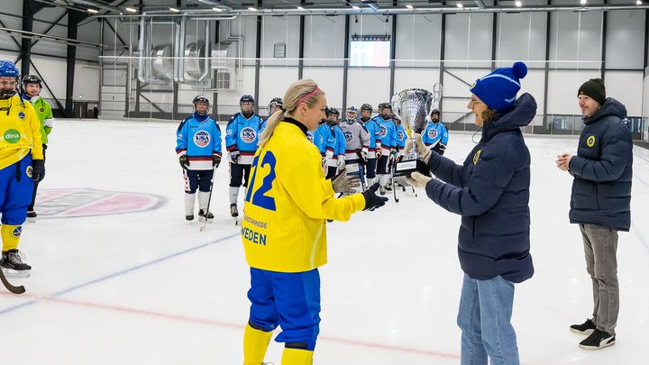 Lagkapten Linnéa Larsson fick motta pokalen för segern i 4 Nations Cup av Svenska Bandyförbundets sportchef, Karin Torneklint.