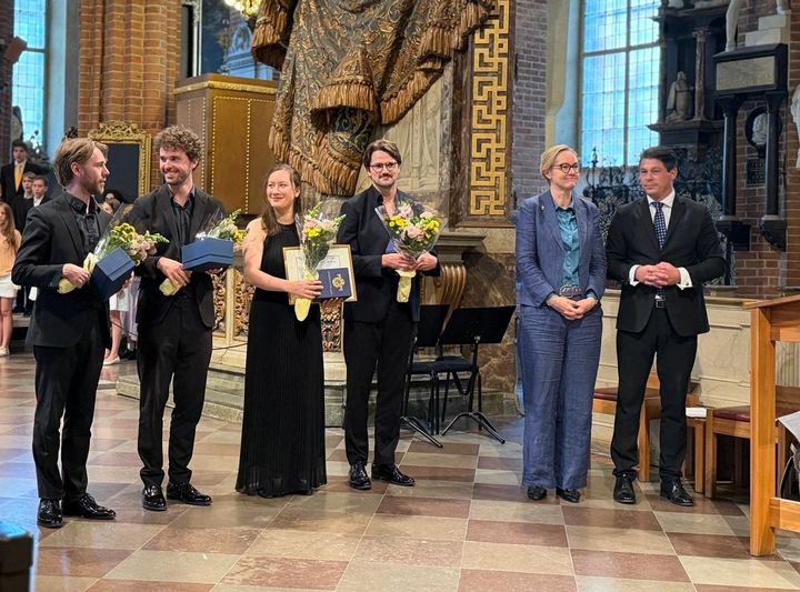 Sex personer står tillsammans vid utdelning av musikstipendium, inklusive musiker, landshövding och representant från Gålöstiftelsen.