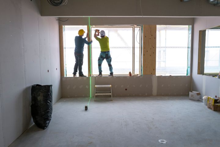 Byggarbetare arbetar med förnstermontering vid Skolfastigheters bygge av nya Brantingsskolan i Uppsala.