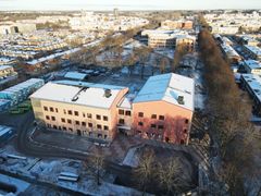 Flygfoto över snötäckt byggplats i Uppsala där en skola byggs.