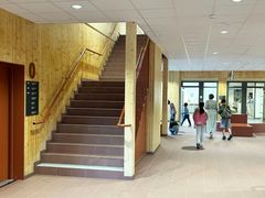 Ny trappa och korridor i Kvarngärdesskolans lokaler med några personer som utforskar området.