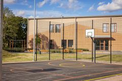 Exteriör av Nya Kvarngärdesskolans byggnad med sportanläggning och basketkorg.