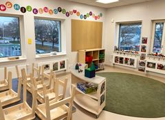 Ett förskoleklassrum med stolar upp och leksaker vid ett fönster.