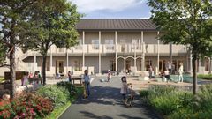 En grupp barn leker på en grön gård framför en stor tvåvåningsbyggnad med träd runtomkring.