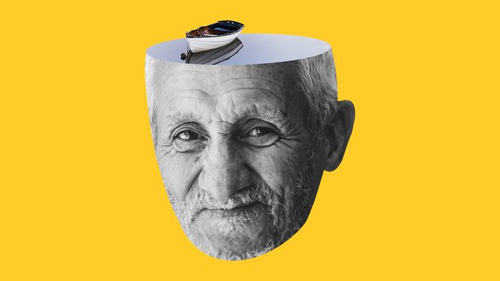 En svartvit bild av en äldre mans ansikte med en liten båt ovanpå huvudet. Bakgrunden är gul.