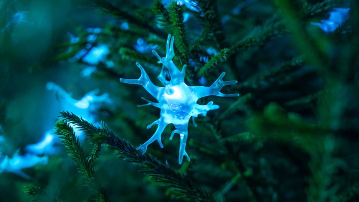 Ljusslinga med blått ljus format som ett neuron på en grön gren.