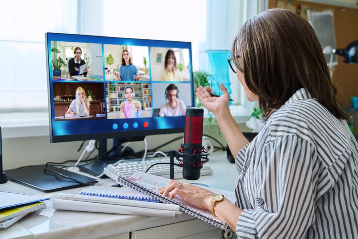 En kvinna sitter i ett digitalt möte vid sin dator.