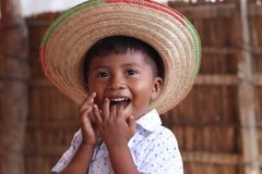 En ung colombiansk pojke med en stor stråhatt ler.