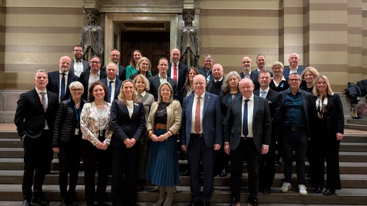 Flera människor står uppställda i rader på fotografiet.