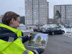 Kommunens projektledare Mats Falås visar upp hur Mörbyplans nya torg ska se ut efter upprustningen. Han håller upp visionsbilden så det går att jämföra nutidsbilden och visionsbilden med samma vy.