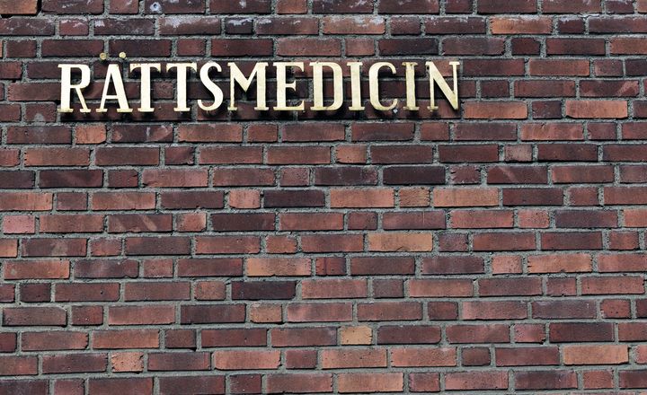 Skylt med texten "Rättsmedicin" på en tegelvägg.