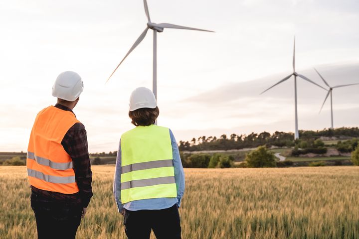 Människor framför vindkraftverk