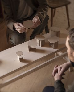 Två personer tittar på små hantverksprodukter.