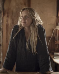 En kvinna står inomhus i en hantverkarmiljö.