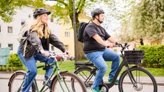Två personer som cyklar i en park