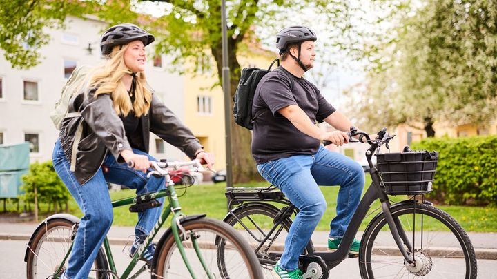 Två personer som cyklar i en park