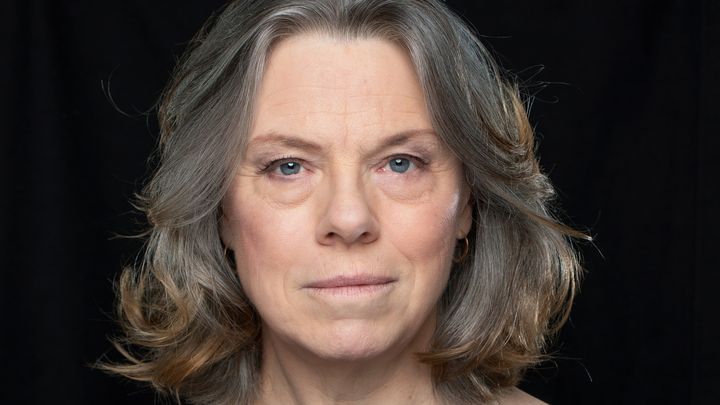 Närbild på kvinna i mörkt hår med svart bakgrund
