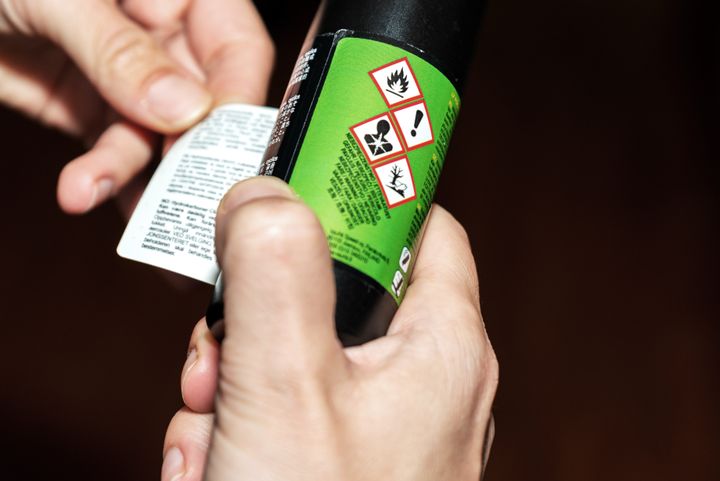 En bild på en etikett på en glasflaska med ett antal varningssymboler på