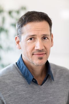 En porträtt bild på Kemikalieinspektionens inspektör Marcus Hagberg. Han har grå tröja och kortklippt mörkt hår.