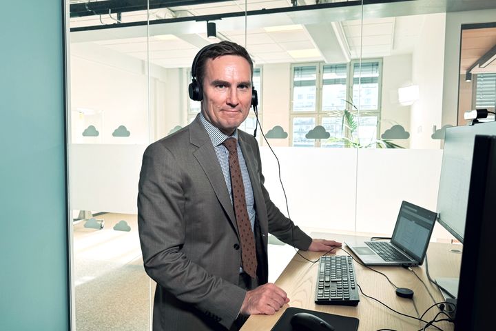 Kemikaileinspektionens generaldirektör står i grå kostym framför ett skrivbord med en dator på.