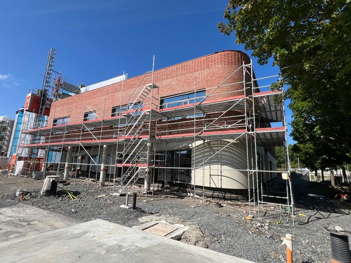 En byggnad i Botkyrka kommun under renovering, omgiven av byggnadsställningar.