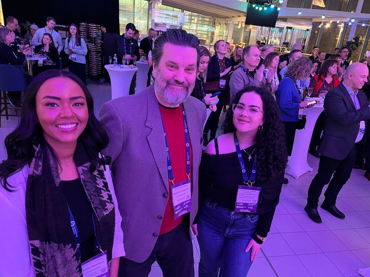 Grupp människor står leende på ett evenemang.