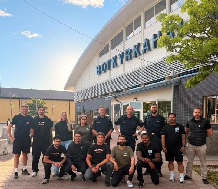 En grupp människor står framför en byggnad med texten "Botkyrkahallen".