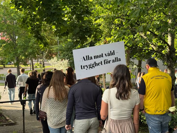 Människor går i ett tåg med skyltar.