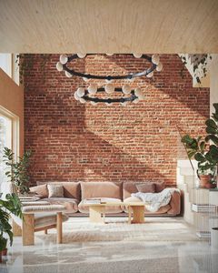 Kvarteret Shoji präglas av återbruk och resurshushållning. Visionsbild av vardagsrummet med dubbel takhöjd och vägg av återbrukat tegel.