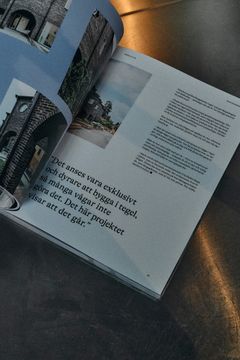 En öppen Okidoki Kokbok som visar en artikel med bilder av tegelbyggnader.